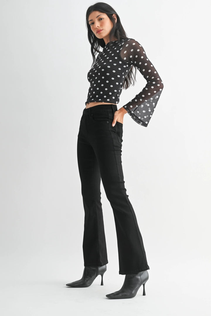 just black denim just USA brand mid rise boot cut black jeans with black leather booties and a black and white polka dot long sleeve top
