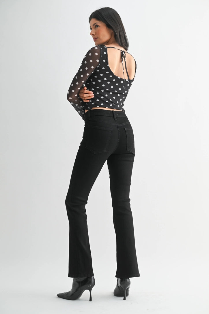 just black denim just USA brand mid rise boot cut black jeans with black leather booties and a black and white polka dot long sleeve top