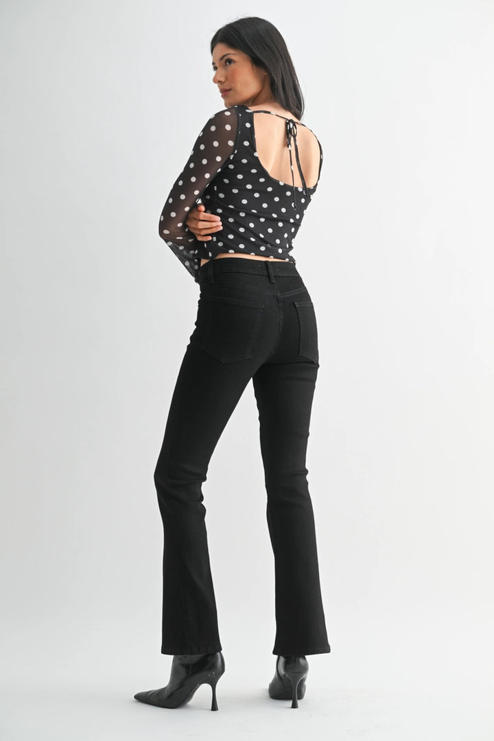 just black denim just USA brand mid rise boot cut black jeans with black leather booties and a black and white polka dot long sleeve top