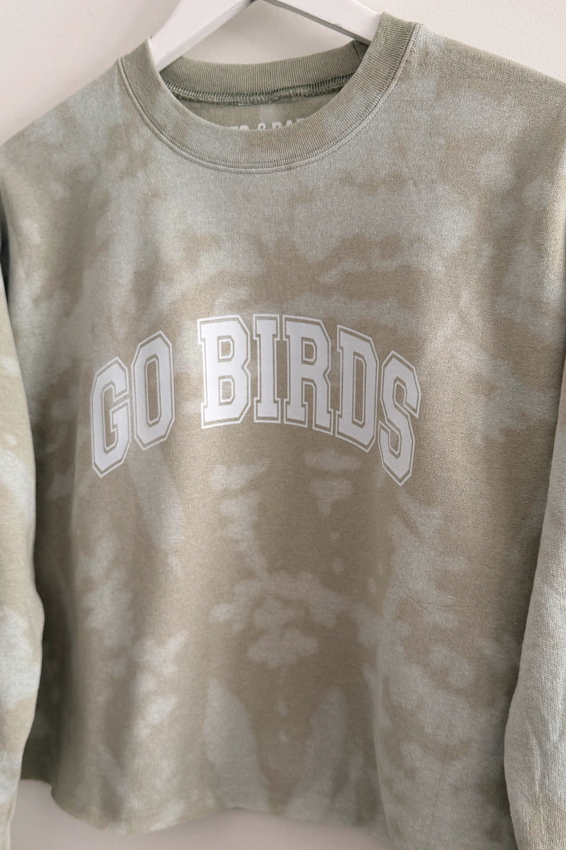 pullover sweatshirt in a light green, sage tie-dye color with "Go Birds" in White varsity lettering on the front
