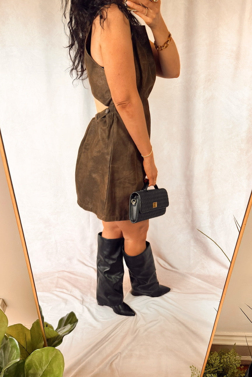 free people atlas suede sleeveless mini dress chocolate brown with a black woven suede handbag and tall black boots accessorized with gold jewelry