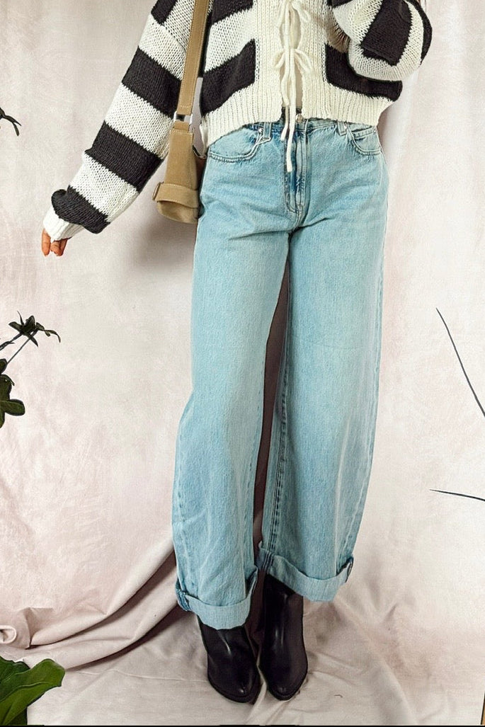 z supply the show off high rise bowed light wash denim with black booties and a striped loose knit cardigan with cream and charcoal stripes