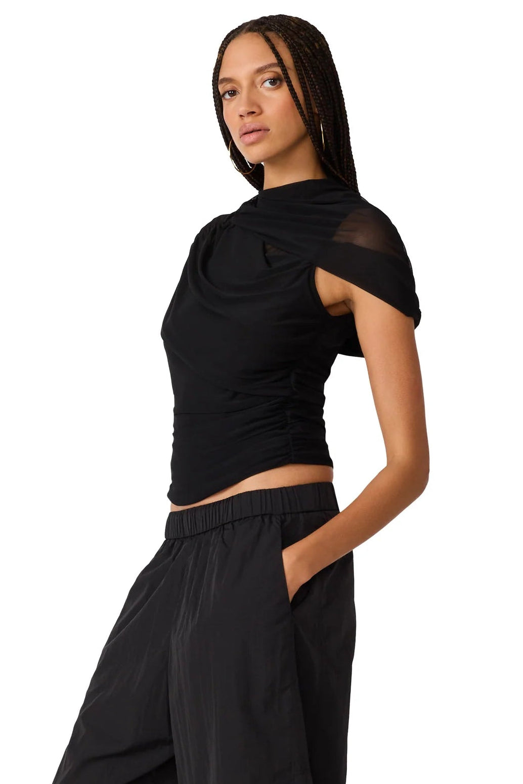  black short-sleeve top with sheer mesh ruching  and a ruched draped neckline, paired with black bottoms and black flats