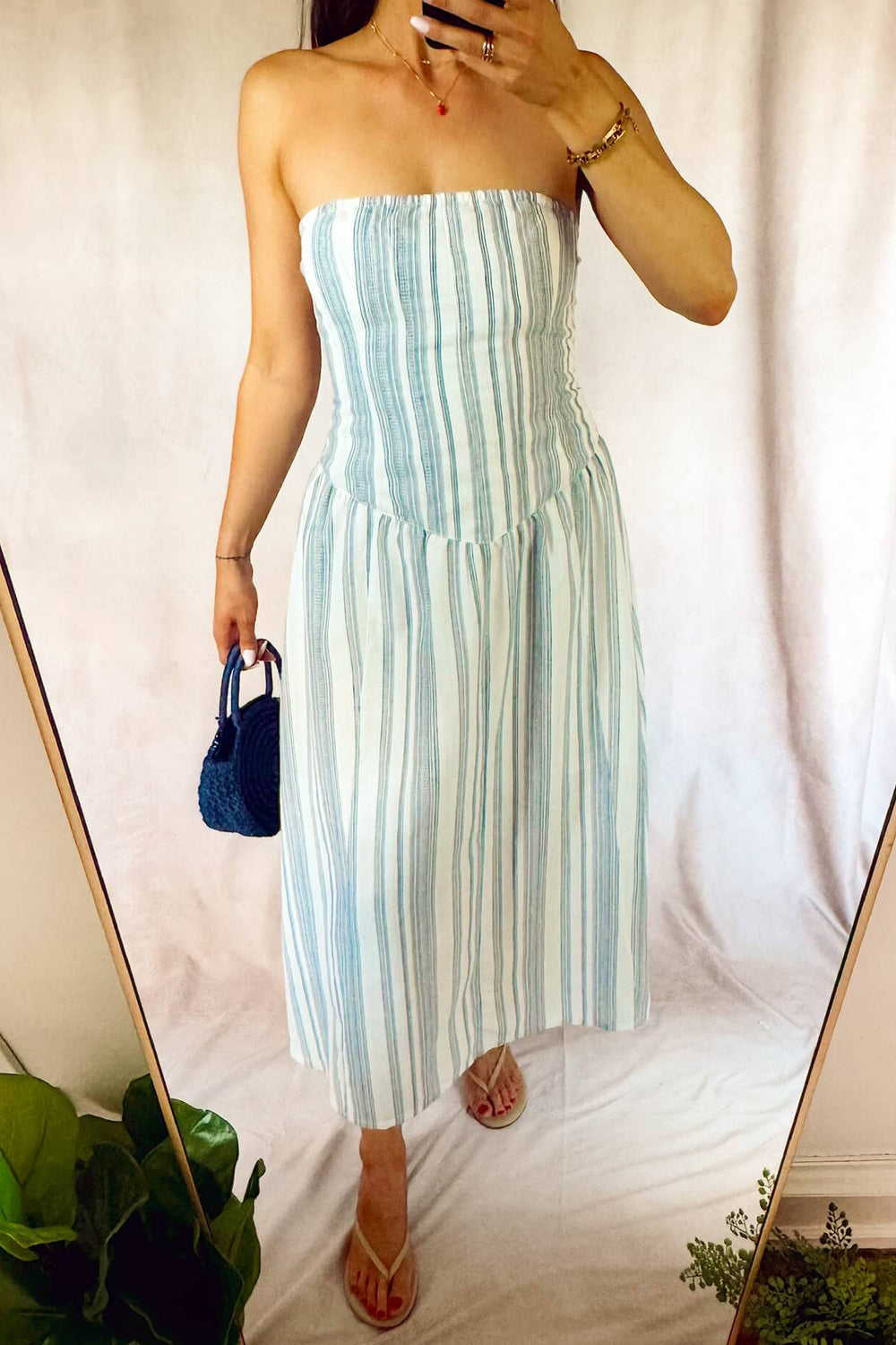 heartloom Ronan strapless midi ankle dress fit and flare eggshell white with navy blue stripes and a dark blue woven purse brass Sand strawberry pendant necklace