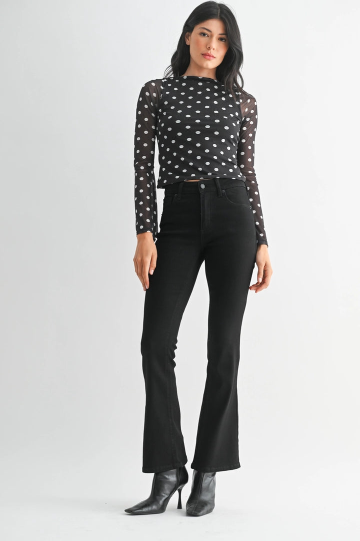 just black denim just USA brand mid rise boot cut black jeans with black leather booties and a black and white polka dot long sleeve top