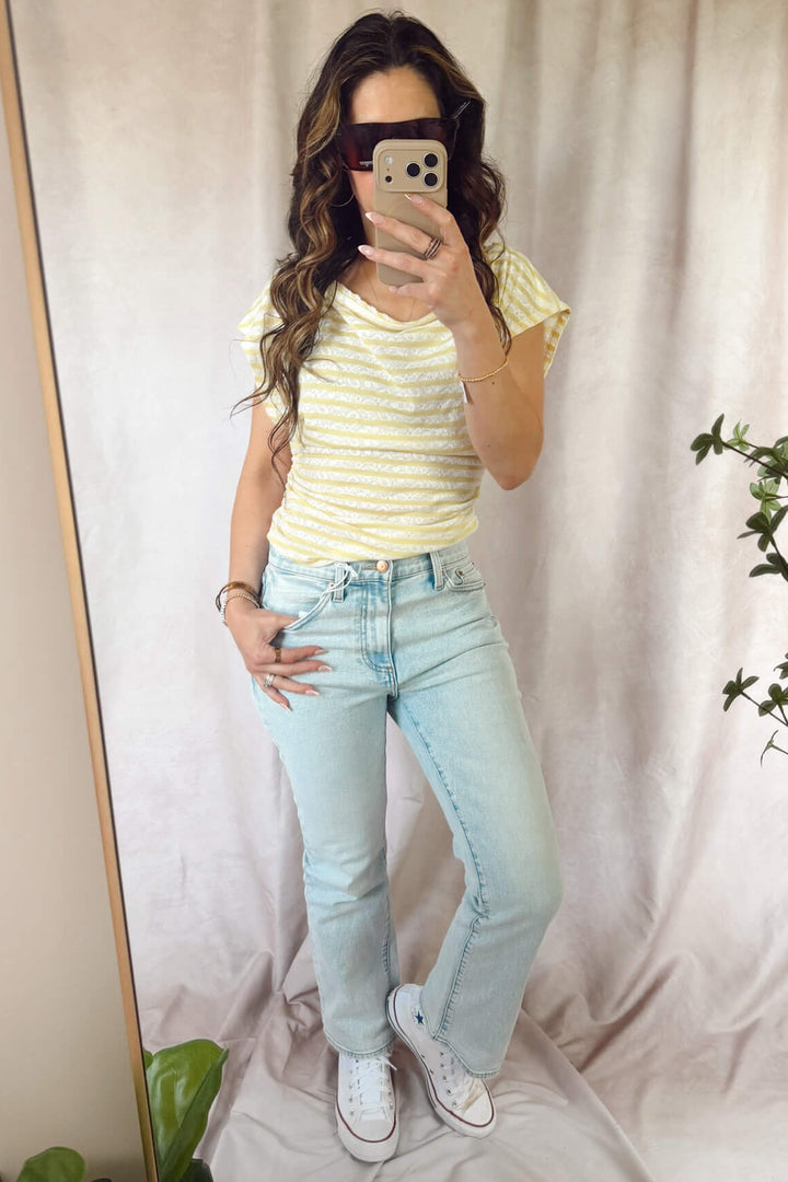 light wash pistola lennon high rise crop boot cut jeans cherish with converse sneakers and free people Ellie top Sicilian combo yellow and white stripe 