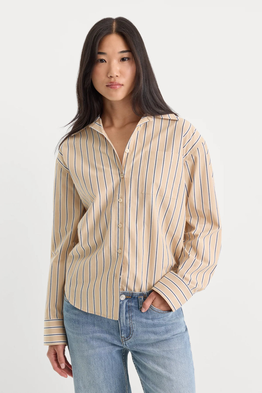 good American the easy poplin shirt long sleeve button front shirt dune tan with thin navy and white stripes paired with light wash denim jeans