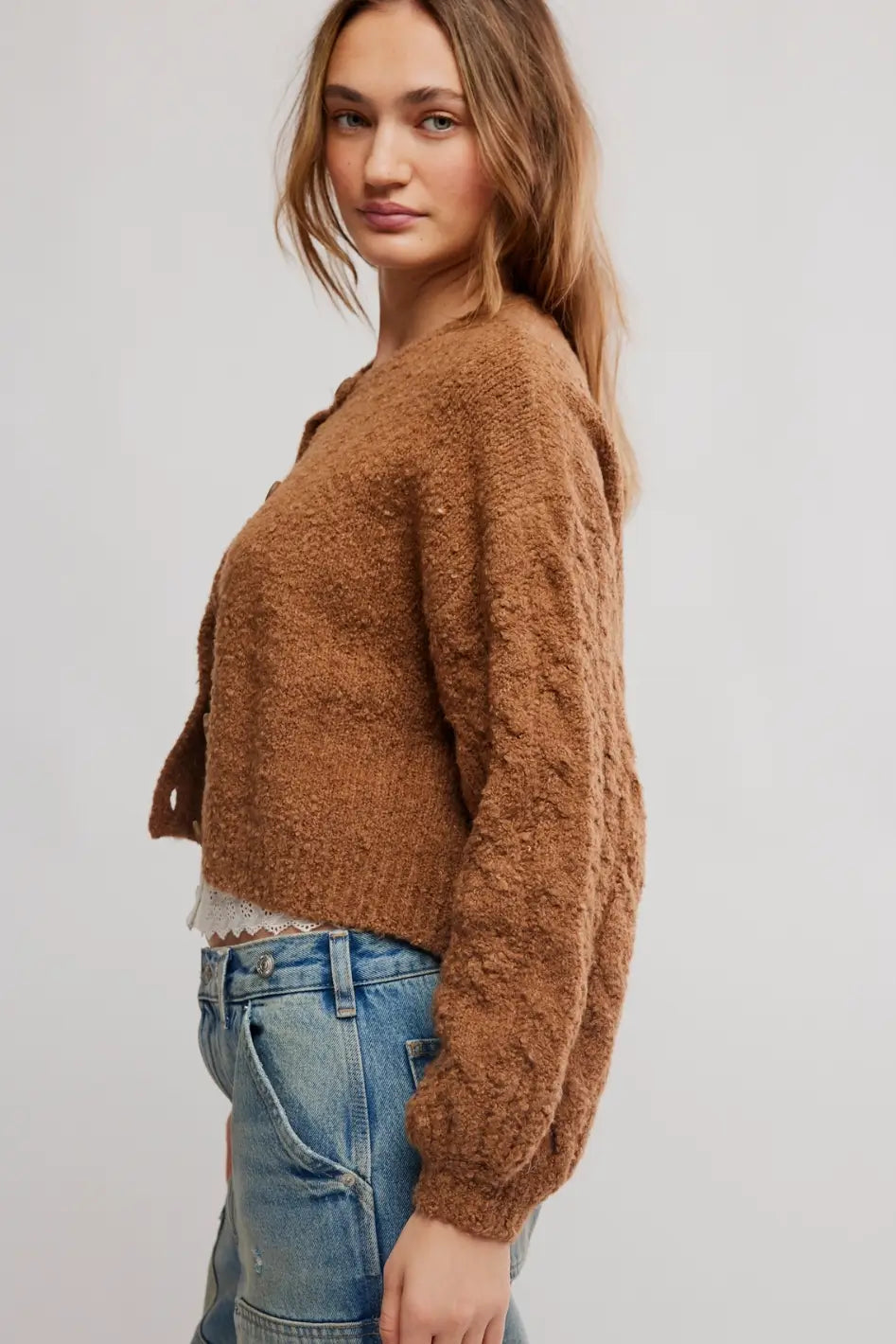 FREE PEOPLE THISTKE cropped, fuzzy brown button-front cardigan over a white lace-trim camisole and blue jeans, photographed against a plain white background