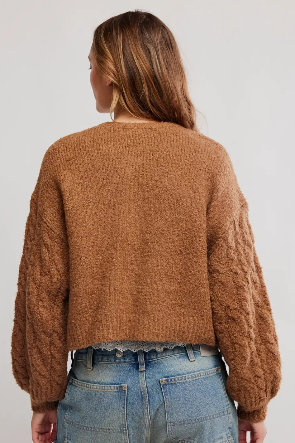FREE PEOPLE THISTlE cropped, fuzzy brown button-front cardigan over a white lace-trim camisole and blue jeans, photographed against a plain white background
