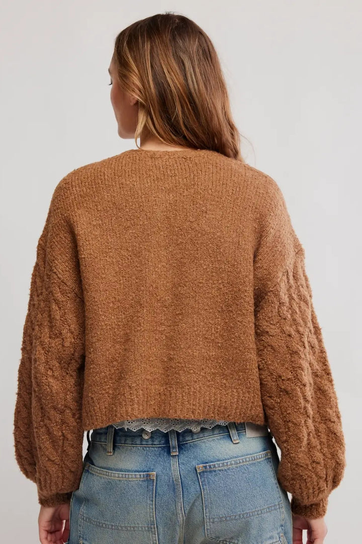 FREE PEOPLE THISTlE cropped, fuzzy brown button-front cardigan over a white lace-trim camisole and blue jeans, photographed against a plain white background