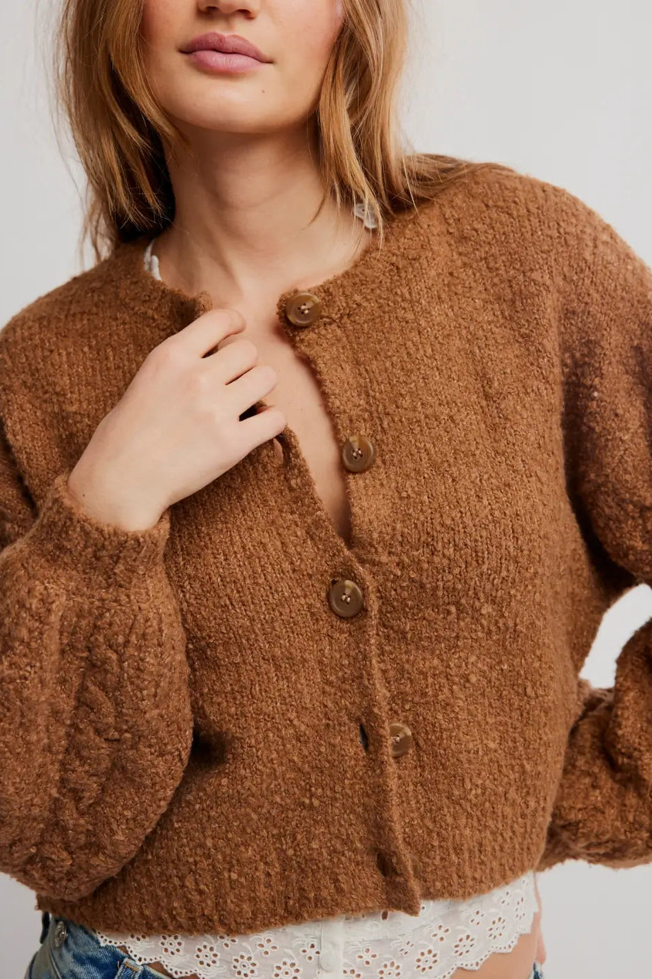FREE PEOPLE THISTKE cropped, fuzzy brown button-front cardigan over a white lace-trim camisole and blue jeans, photographed against a plain white background