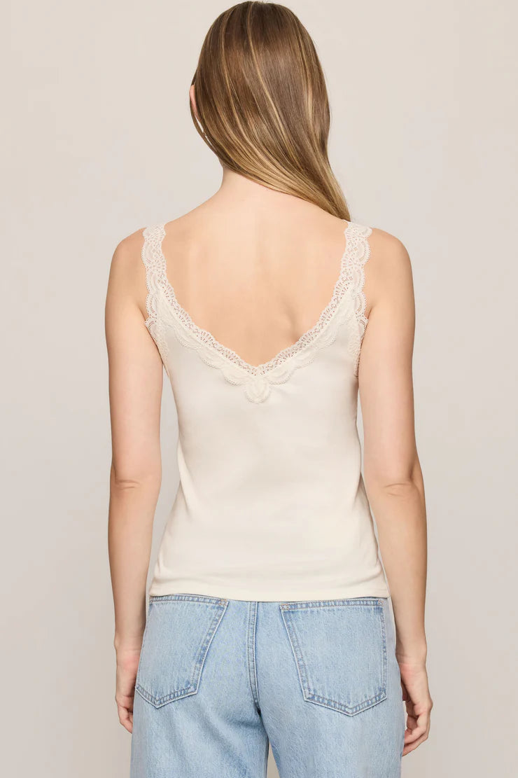 z supply eve off white sand stone lace tank top and blue jeans against a plain background